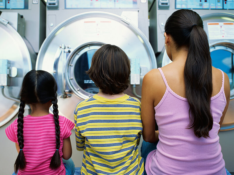 niñas mirando a una lavadora 